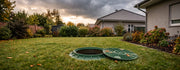 Geöffnete Zisterne im herbstlichen Garten vor aufziehendem Regen